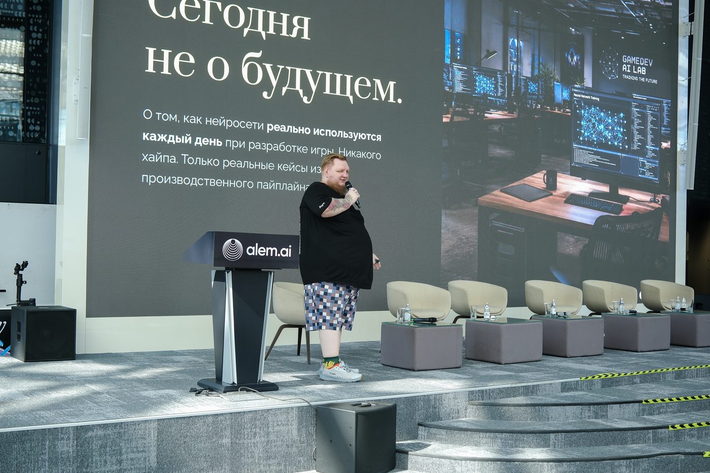 Спикер на сцене, на экране слайд о применении нейросетей в разработке игр